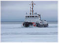 A Coast Guard Tug breaks the ice
